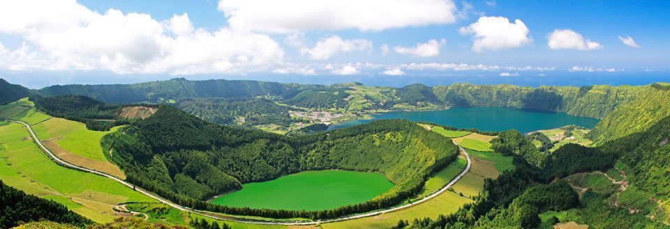 Panoramautsikt over frodige, grønne vulkanske kratersjøer omringet av skogkledde åser.