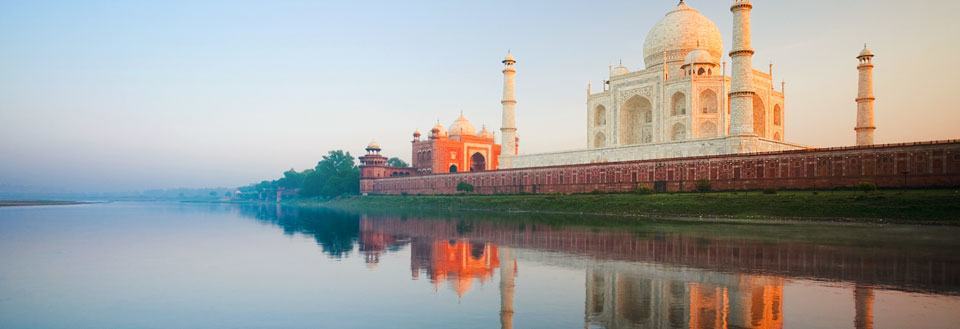 Taj Mahal ved Yamuna-elven i kveldssolen, reflektert i vannet.