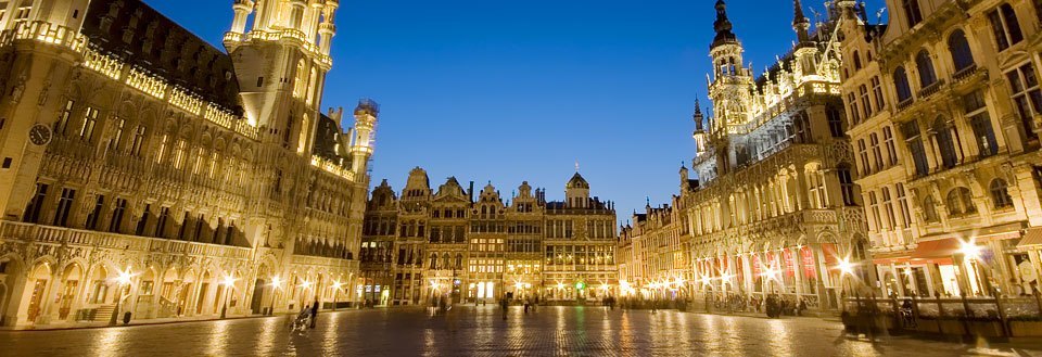 Bildet fremviser Grand Place i Brussel ved kveldstid, belyst og spektakulær med sin arkitektur.