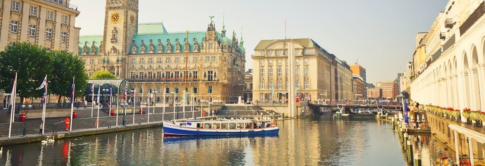 Bildet fremviser Spree Floden i Berlin med båter, omkranset av historiske bygninger og flagg.
