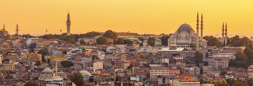 Solnedgang over horisonten i Istanbul med moskeer og tett urbane strukturer.