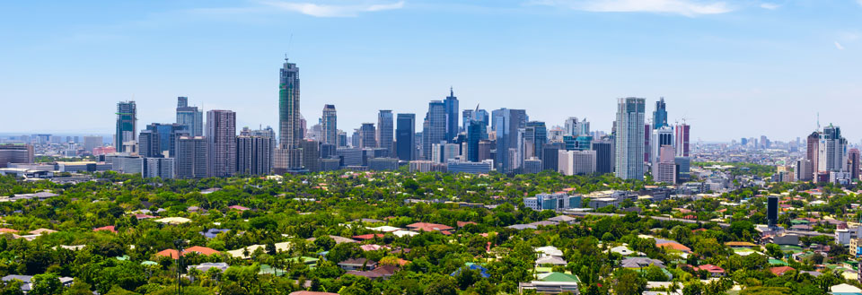 Panoramautsikt over by med moderne skyskrapere omkranset av grøntområder.