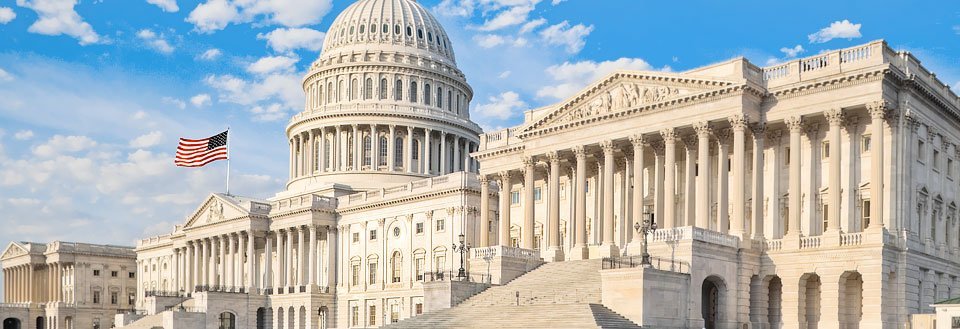 Det staselige, hvite bygningskomplekset til den amerikanske Kongressen under blå himmel i Washington D.C.