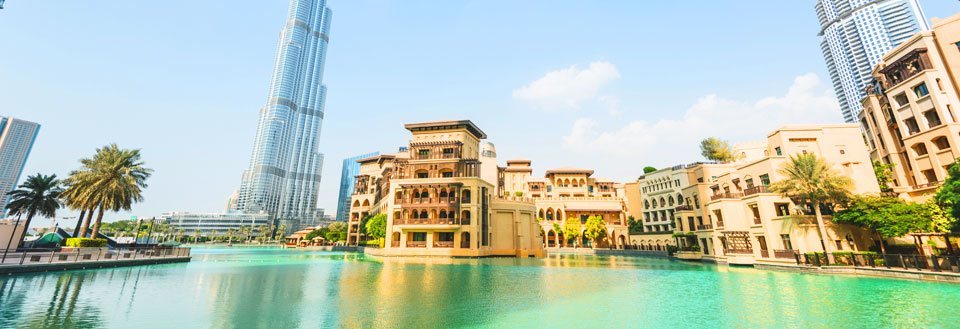 Dubai med skyskrapere og tradisjonell byggestil ved en menneskeskapt innsjø.