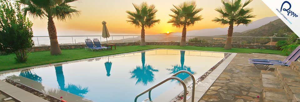 Et svømmebasseng omringet av palmer med utsikt over havet og en solnedgang i bakgrunnen.