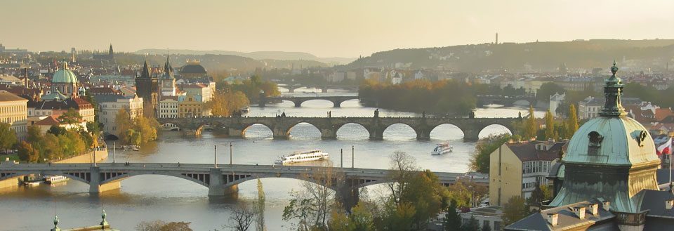 Prahas silhuett med flere broer over elven Vltava i det gylne kveldslyset.