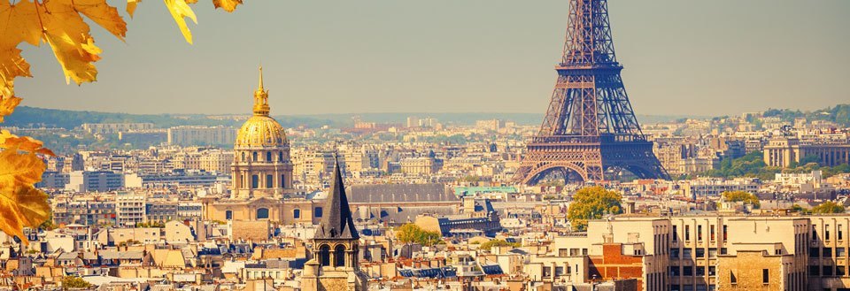 Paris' silhuett med Eiffeltårnet og den gylne kuppelen til Les Invalides på en solrik dag.