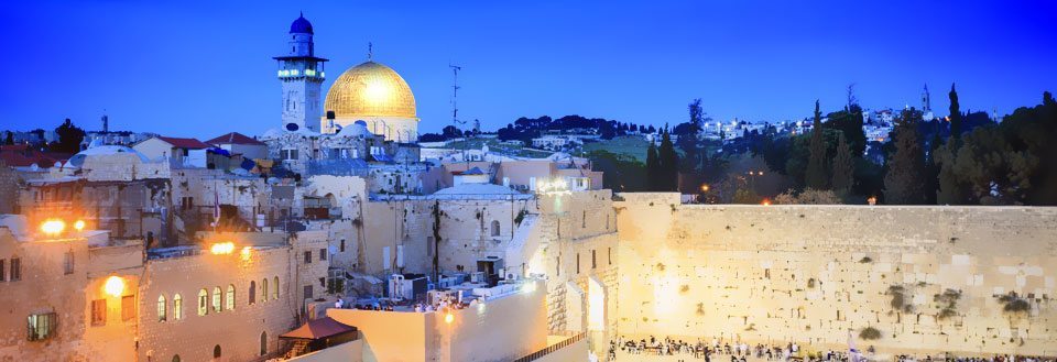Kveldsbilde av Vestmuren og Klippemoskeen i Jerusalem, opplyste bygninger og folk ved muren.