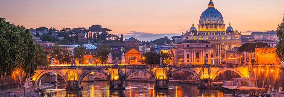 Peterskirken og Engelsborg ved Tiberelva i Roma ved skumring, med lysene på og en vakker himmel.